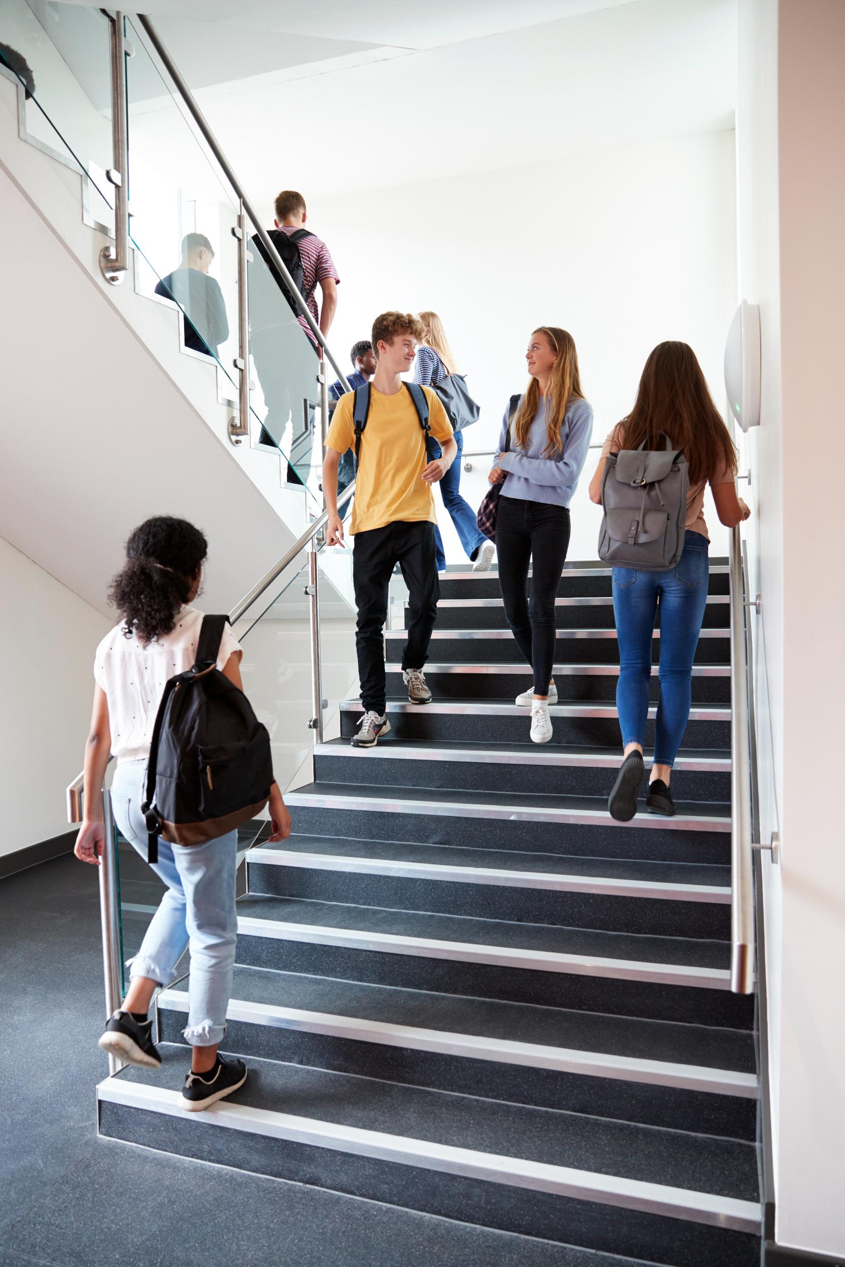 high-school-students-walking-on-stairs-between-les-2021-08-26-16-15-16-utc